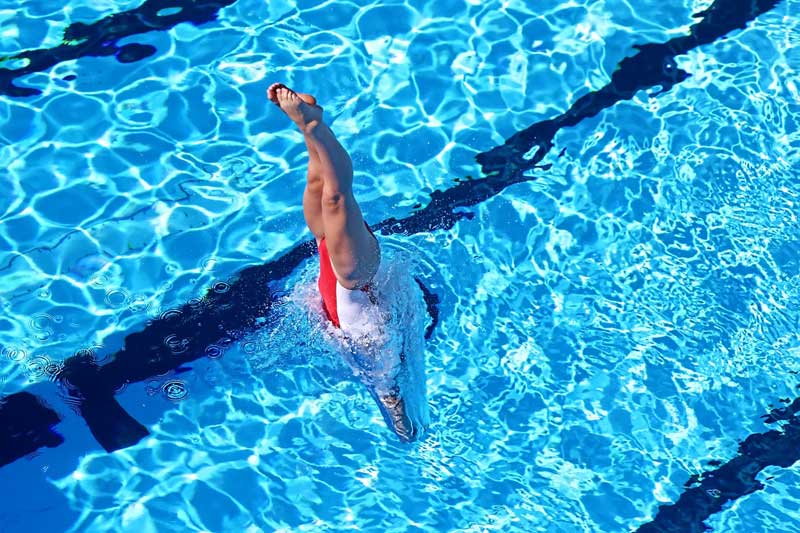 Person diving into pool, an analogy for diving into your first website